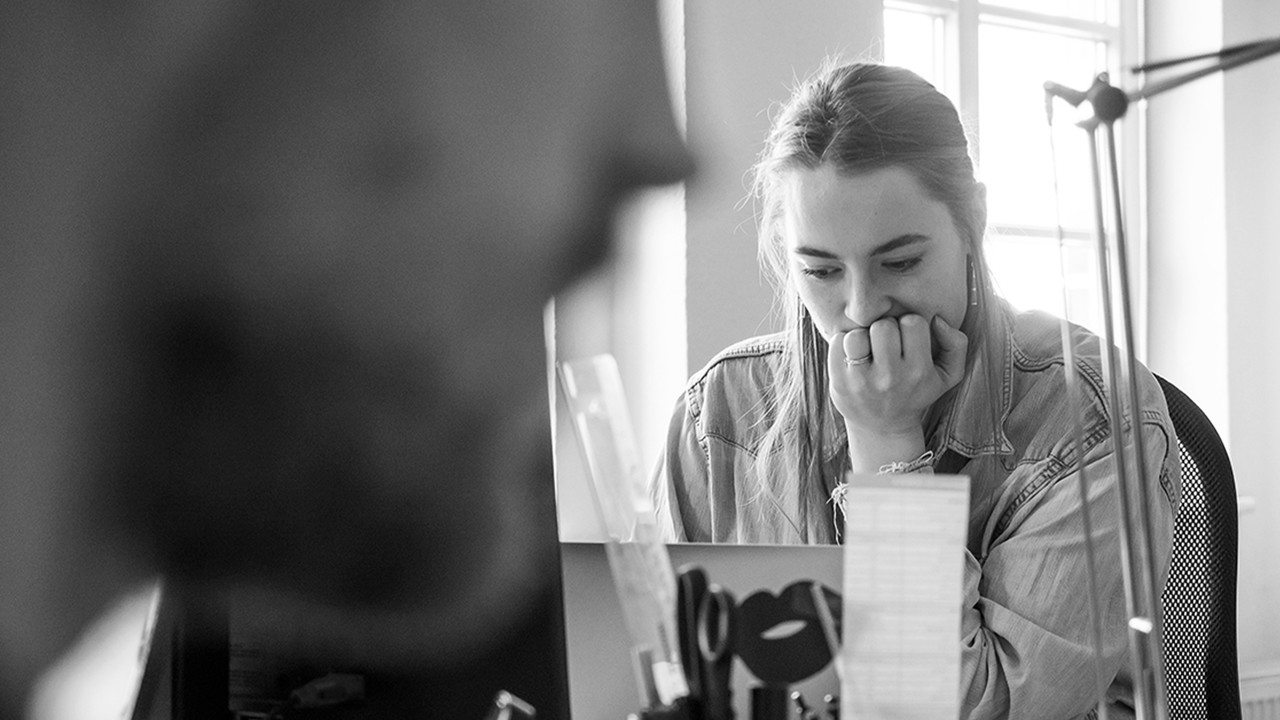 DREHMOMENT Mitarbeiterin arbeitet konzentriert am Schreibtisch