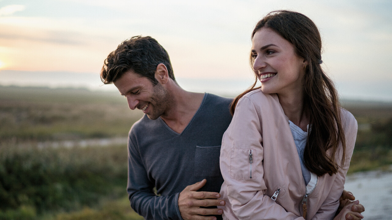 StrandGut Resorts lachendes junges Paar in Heidelandschaft in St. Peter-Ording