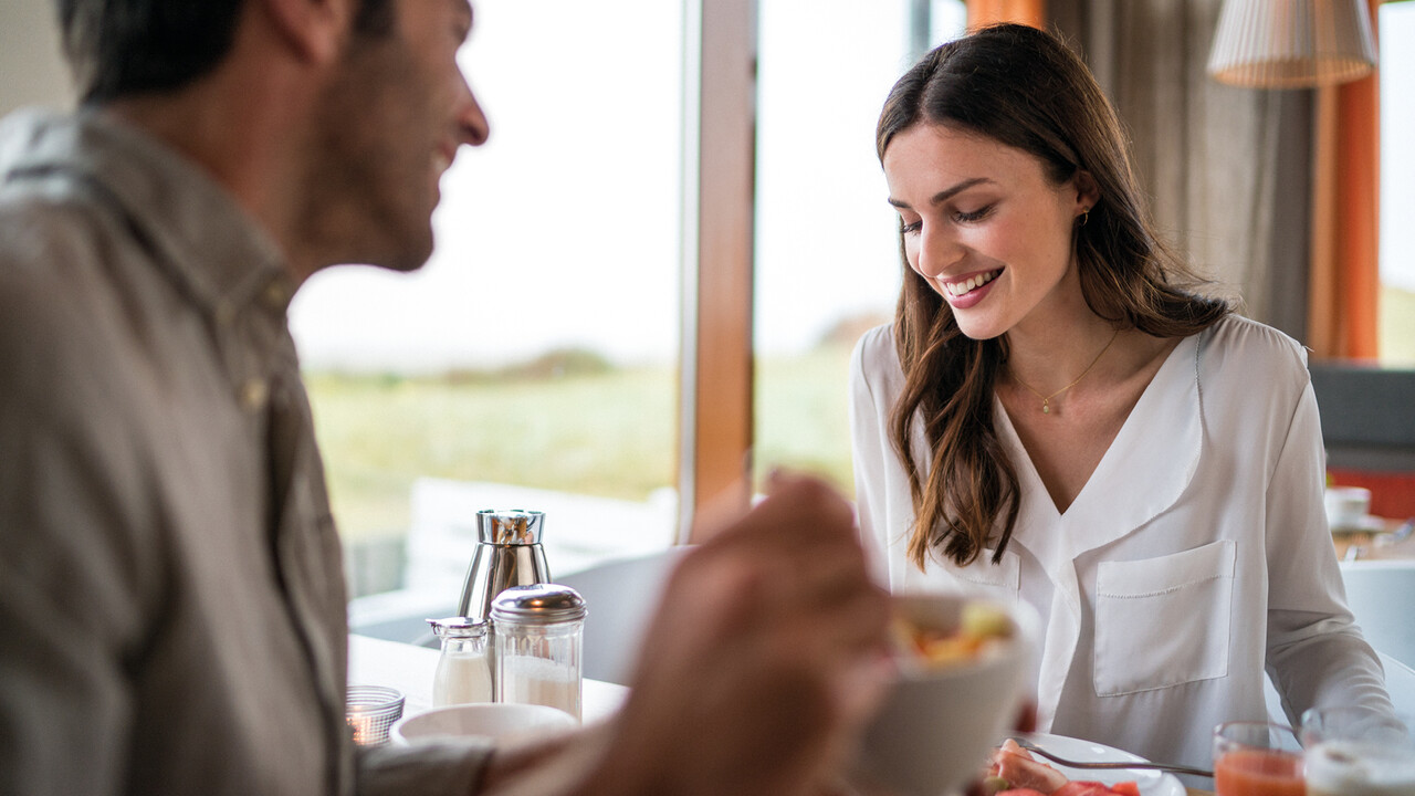StrandGut Resorts glueckliches Paar fr&uuml;hst&uuml;ckt im StrandGut Resort in St. Peter-Ording